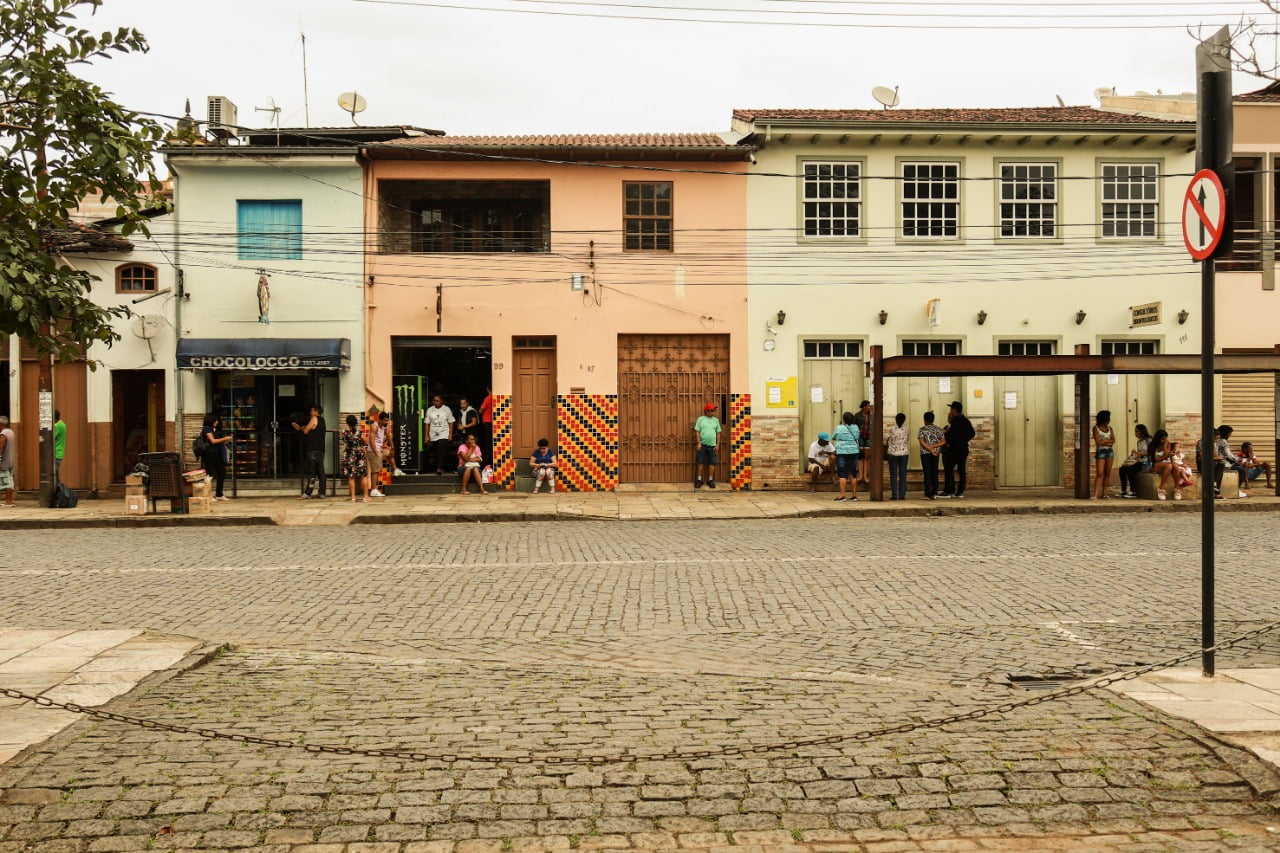 Pessoas no ponto de ônibus da Praça Tancredo Neves, em Mariana