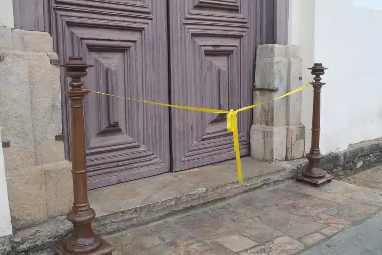 Fita amarela simbólica, instalada na porta principal, para a sessão de reabertura da Catedral de Mariana