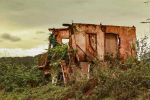 A imagem mostra uma das casas de Bento Rodrigues em ruínas após o rompimento da Barragem de Fundão que gerou o PID.