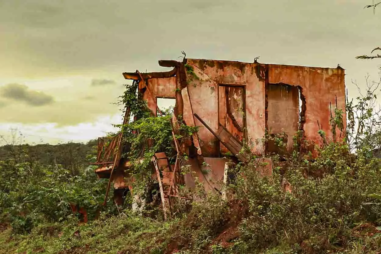 A imagem mostra uma das casas de Bento Rodrigues em ruínas após o rompimento da Barragem de Fundão que gerou o PID.