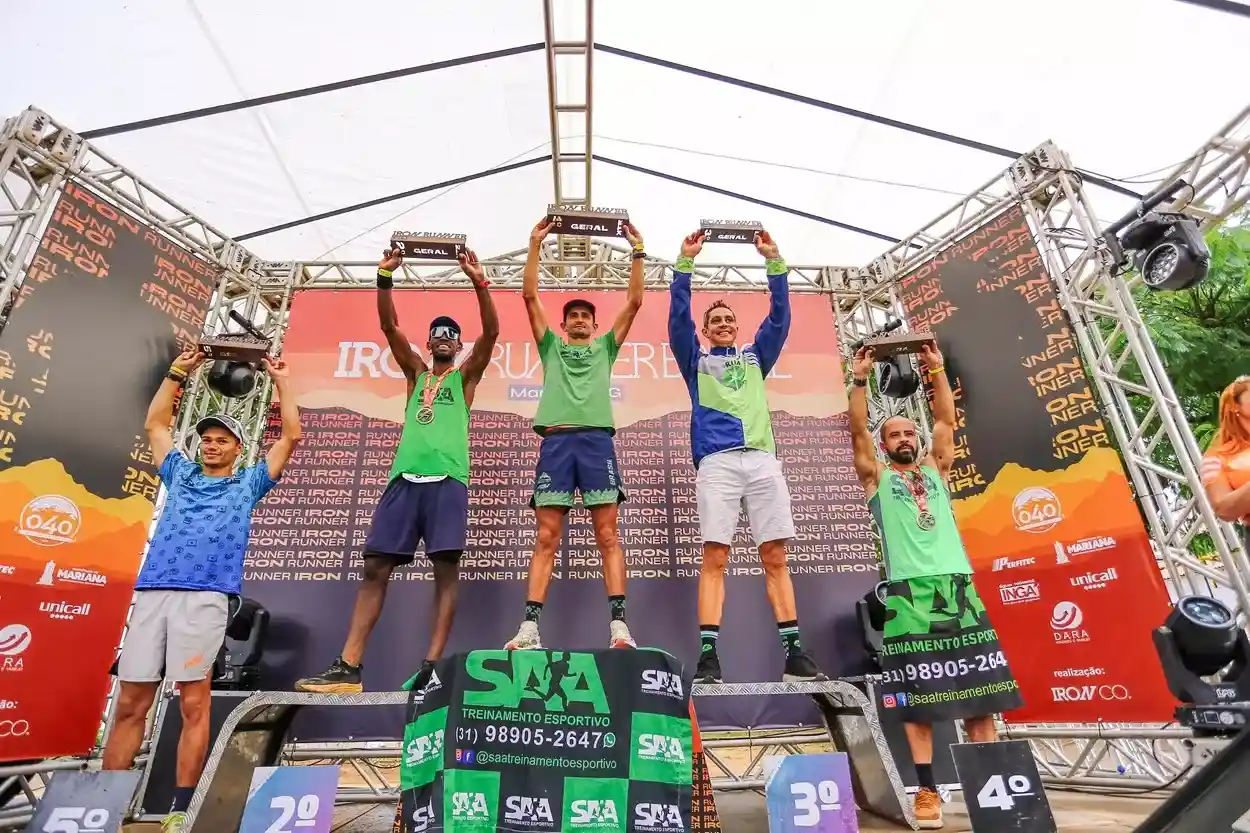 Atletas no pódio masculino do Iron Runner em Mariana, comemorando com troféus levantados.