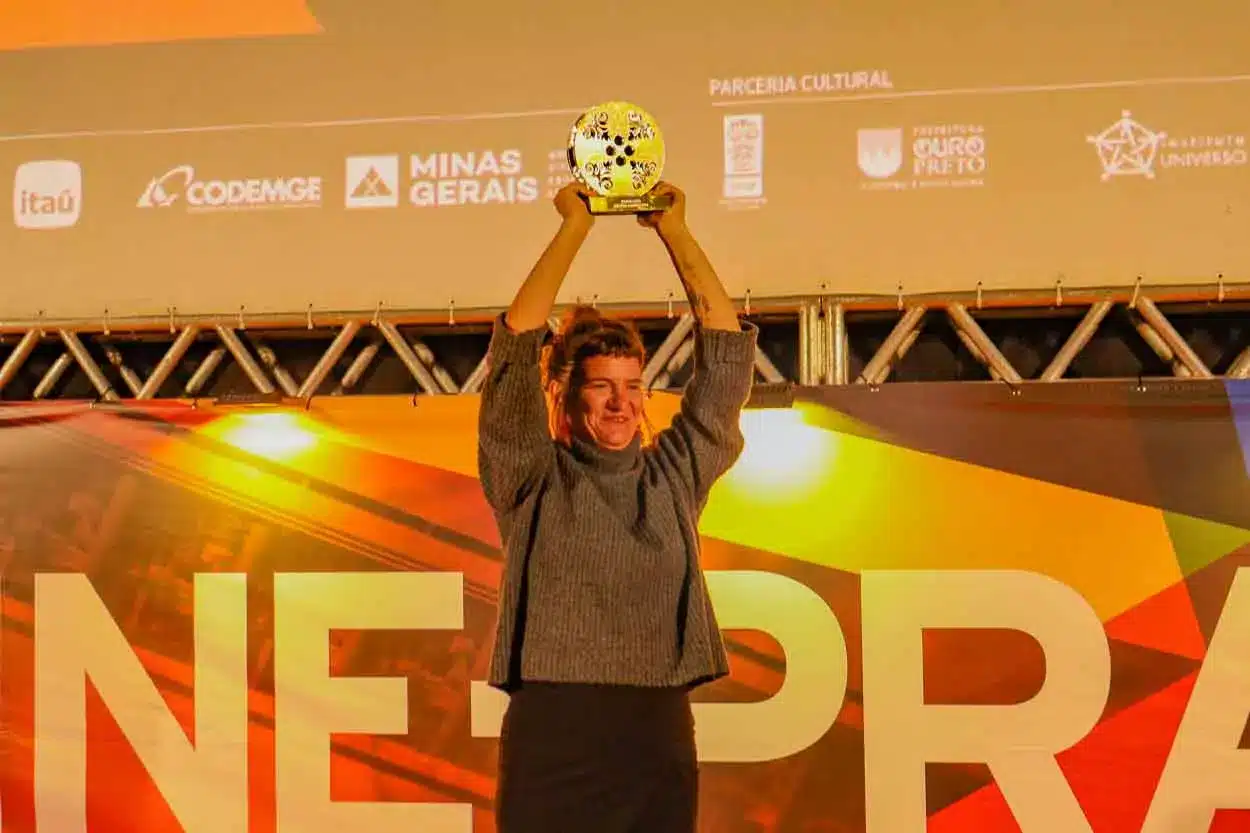 A cineasta Ana Rieper levanta o troféu Vila Rica no encerramento da CineOP, o troféu premia o melhor longa contemporâneo da mostra, Paraíso.