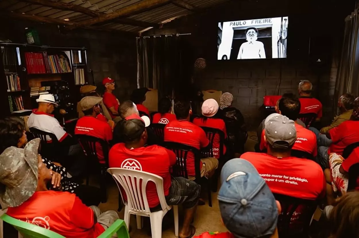 Moradores da Ocupação Chico Rei assistem à sessão de abertura do cineclube, que exibiu um documentário sobre Paulo Freire.