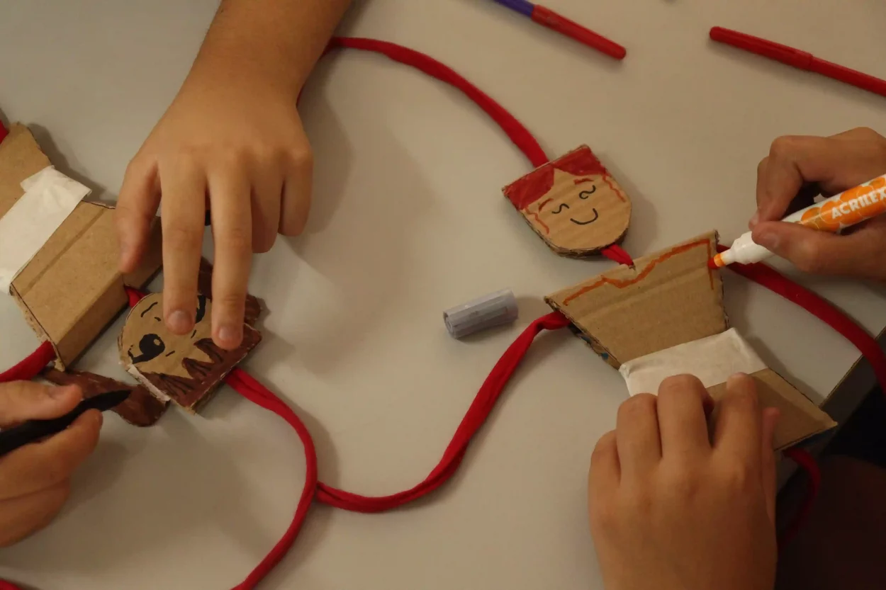 Crianças fazem boneco reciclavel com o projeto Caixola Recicla