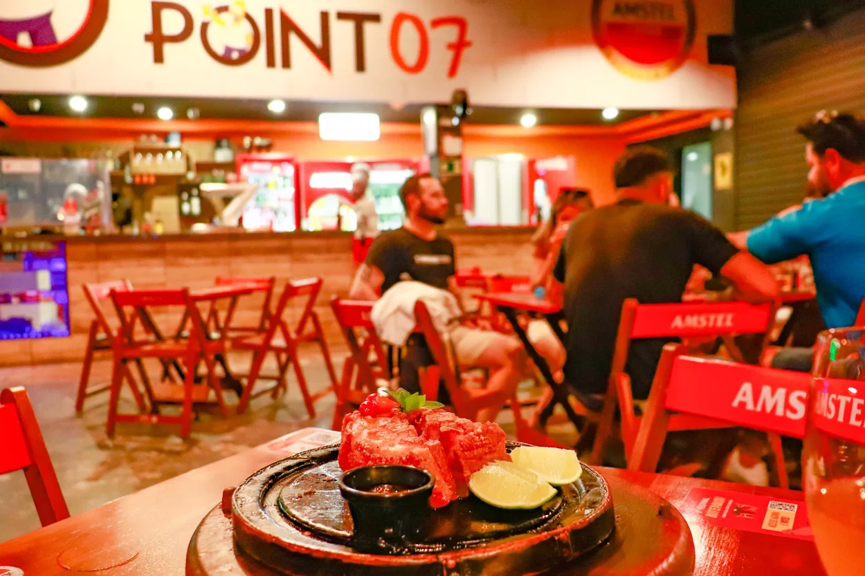 Em detalhe observamos o prato de pedra com o toucinho de rolo empanado com a geléia de pimenta e um limão partido, ao fundo está escrito Point 07