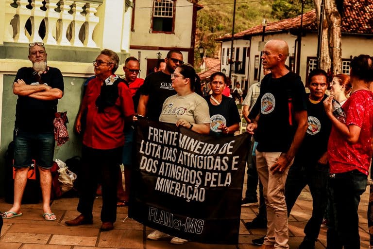 Na foto é possível ver pessoas da Universidade e da comunidade reunidas para o ato de um minuto de sirene no jardim.
